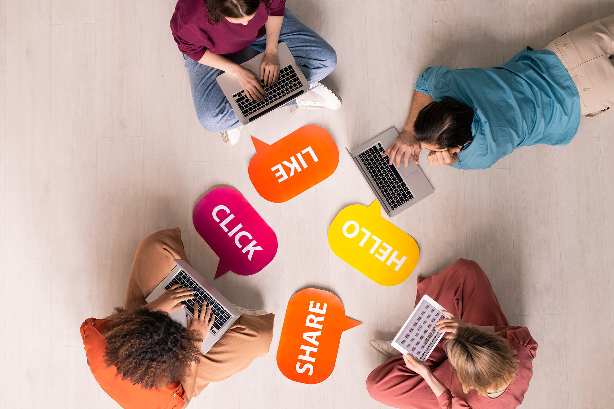 Above view of young people sitting and lying on floor with internet activity tags and using modern portable devices, social media addiction concept