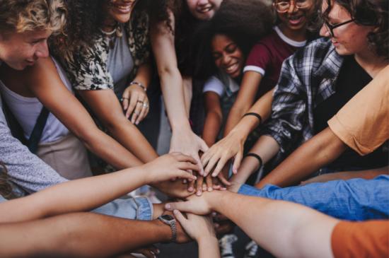 Young multicultural people joining hands